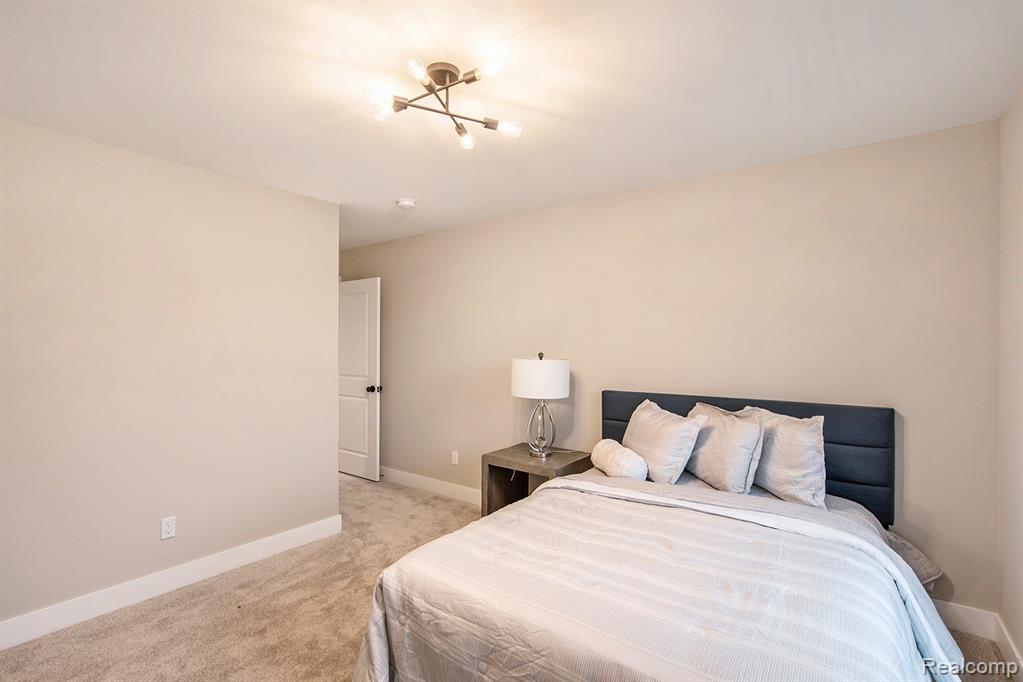 Bedroom featuring light colored carpet and baseboards
