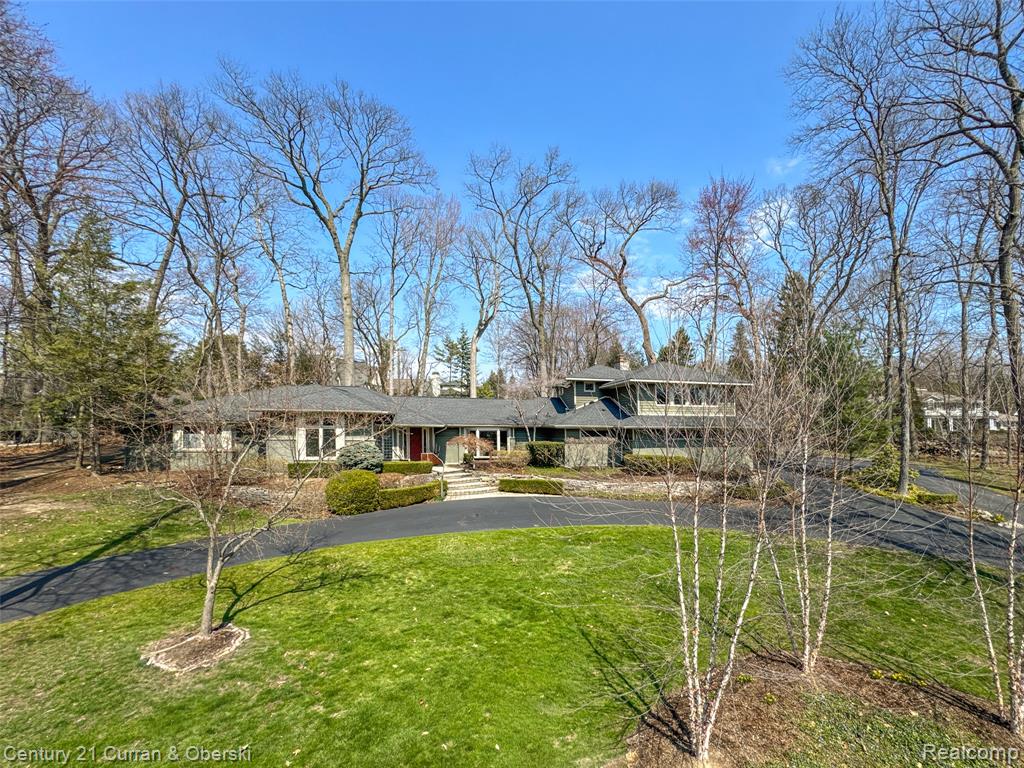 View of front of house with a front yard and curved driveway