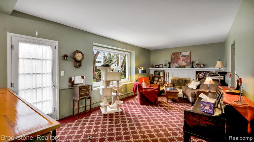 Sitting room featuring a brick fireplace, a baseboard heating unit, and baseboard heating