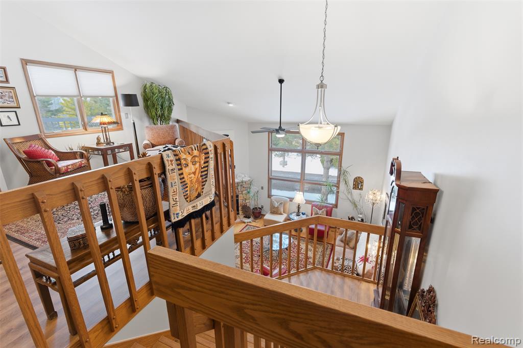 Stairway featuring wood finished floors, plenty of natural light, and ceiling fan