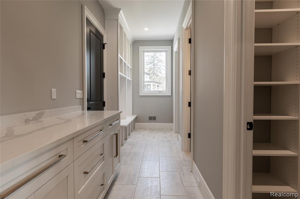 Bathroom with a closet, vanity, and recessed lighting