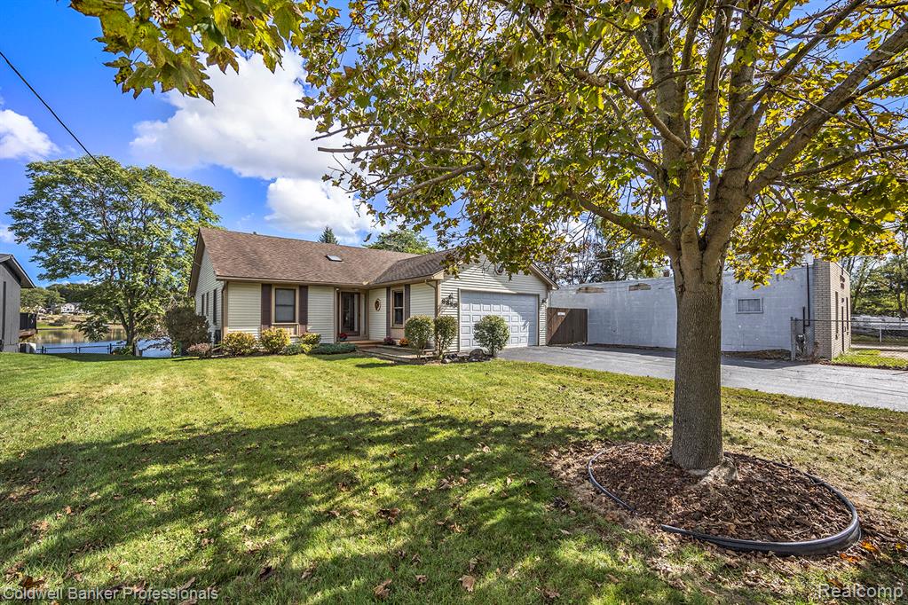 Ranch-style home featuring spacious driveway and an attached garage