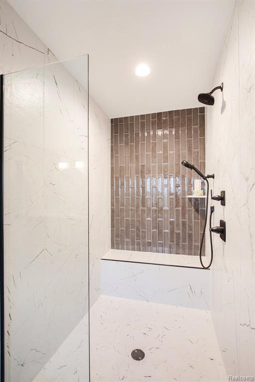 Full bathroom with a marble finish shower and recessed lighting