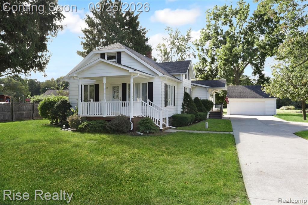 White exterior with black shutters and a covered front porch featuring white railings