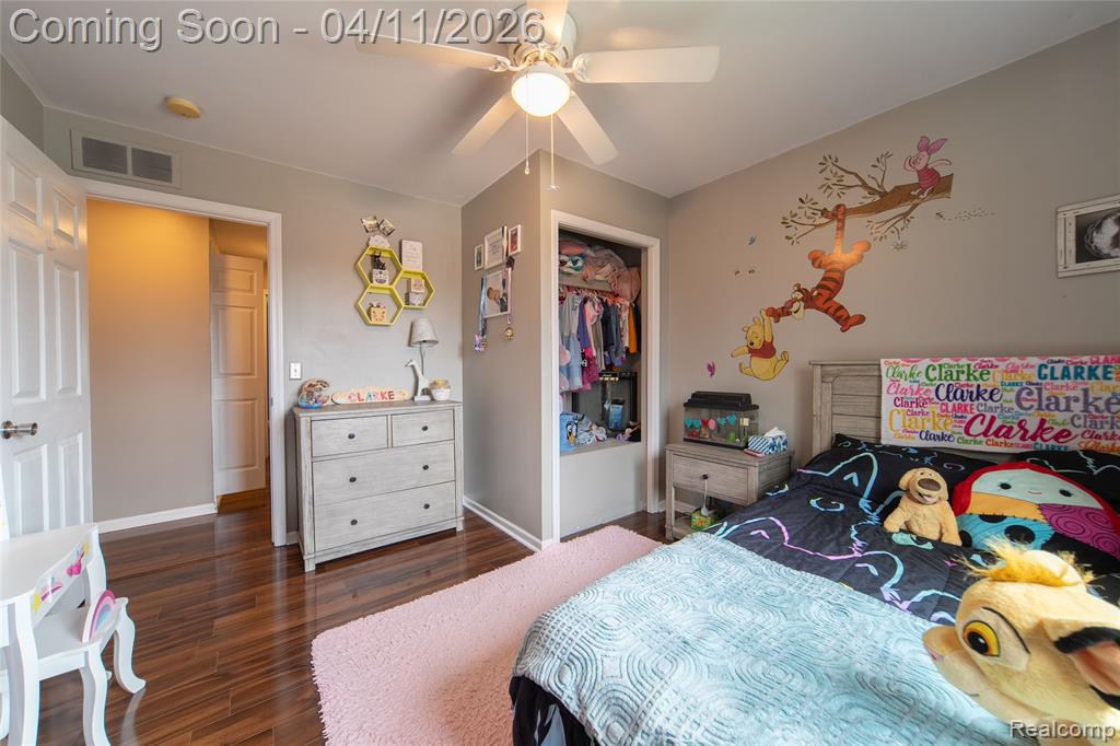 Bedroom with a closet, dark wood-style flooring, and ceiling fan