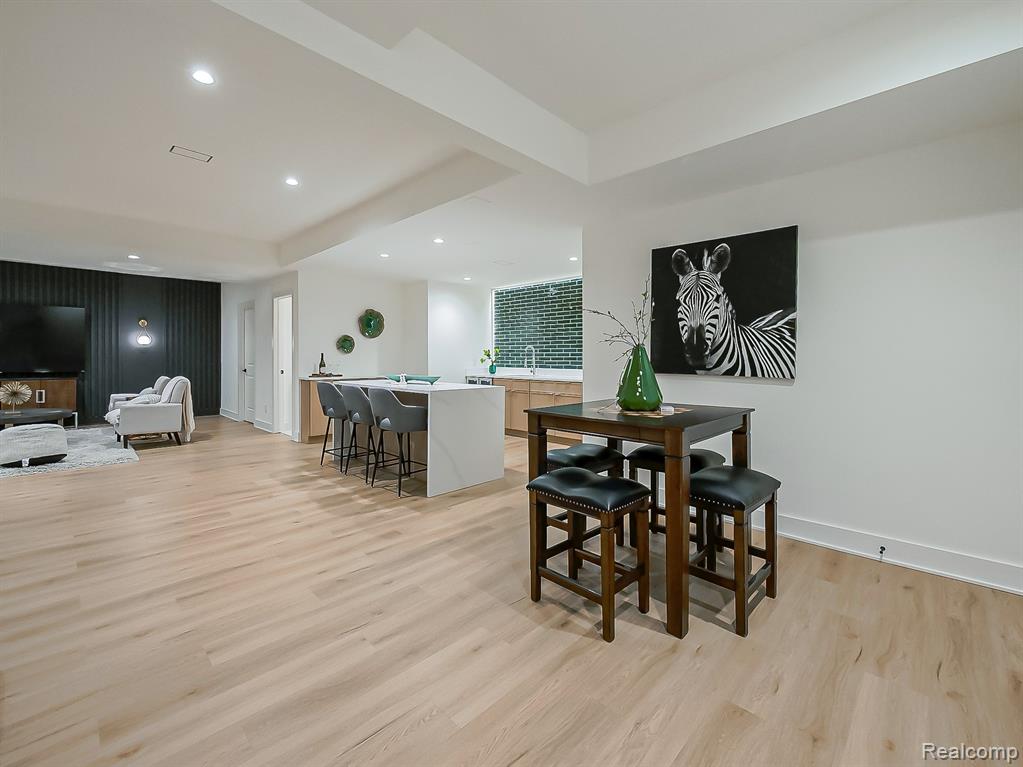 Dining space with recessed lighting, light wood finished floors, and an accent wall