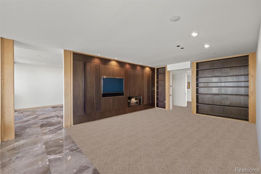 Unfurnished living room with recessed lighting and wood walls