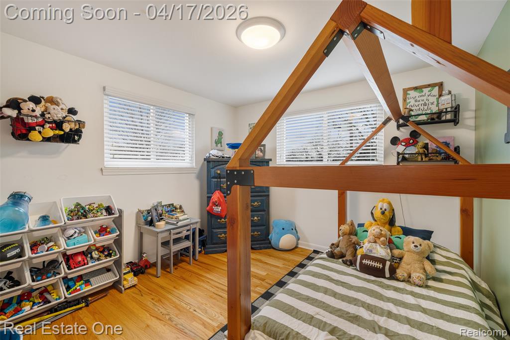 Bedroom with multiple windows and light wood-style floors