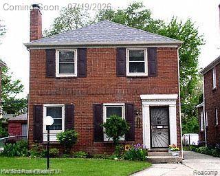 Two-story brick facade with dark shutters and white window trim