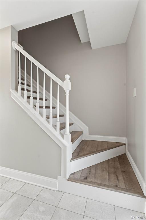 Stairs with baseboards and tile patterned floors