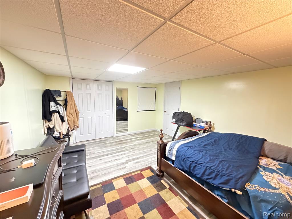 Bedroom with a drop ceiling and wood finished floors