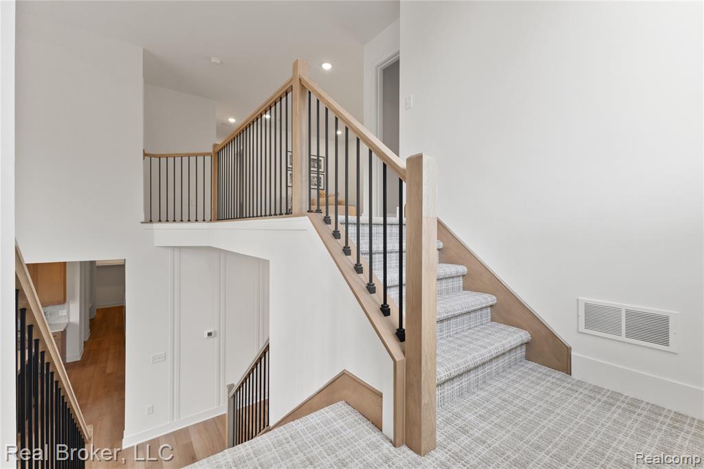 Stairs featuring recessed lighting and wood finished floors