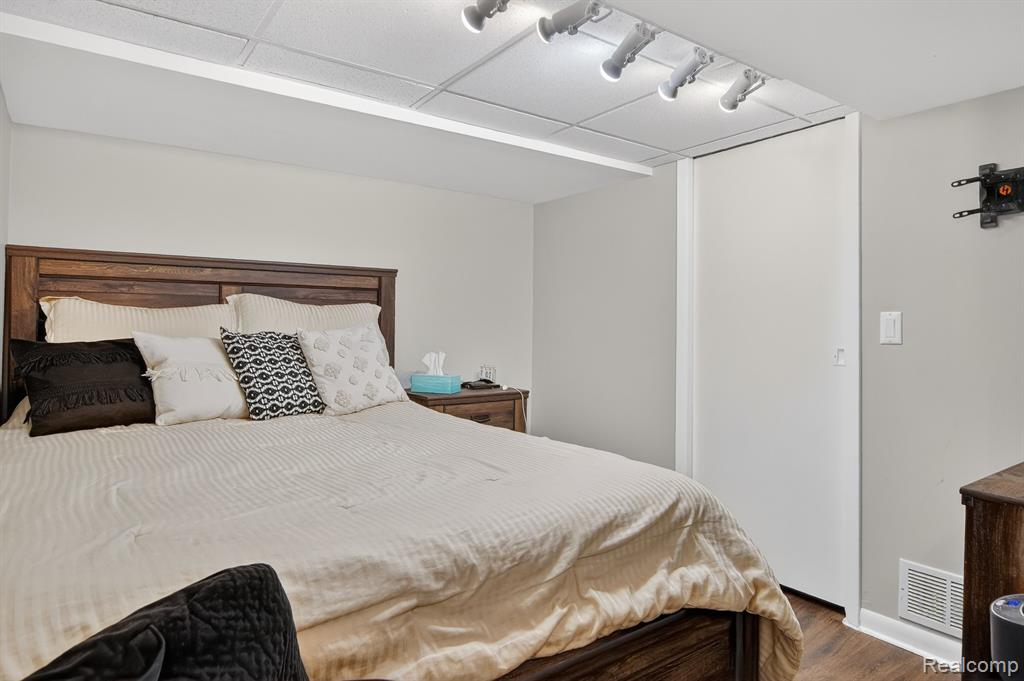 Bedroom with dark wood finished floors and a drop ceiling