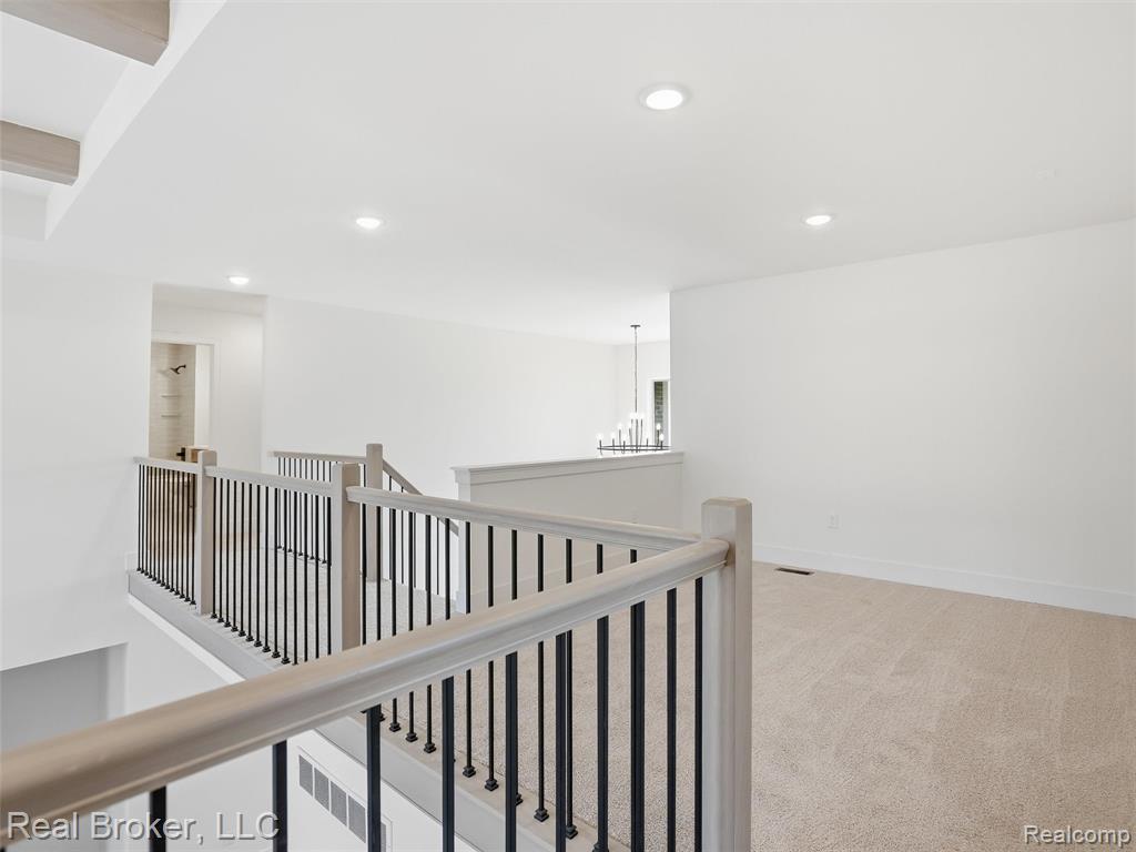 Corridor with light colored carpet, an upstairs landing, and recessed lighting