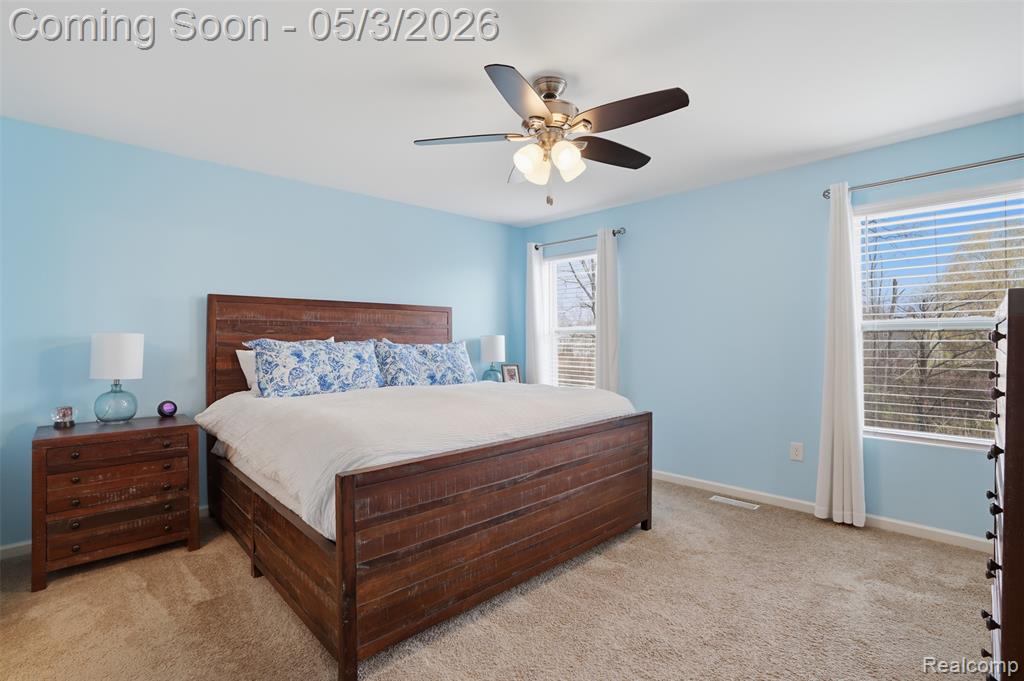 Bedroom with light carpet and a ceiling fan