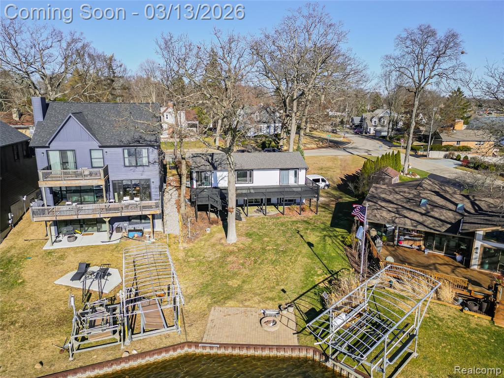 Aerial view of property and surrounding area with a nearby body of water and nearby suburban area