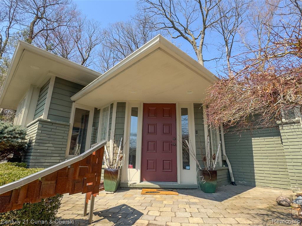Doorway to property with brick siding and covered porch