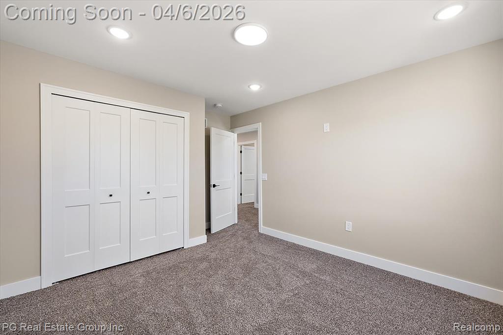Unfurnished bedroom with dark carpet, a closet, and recessed lighting