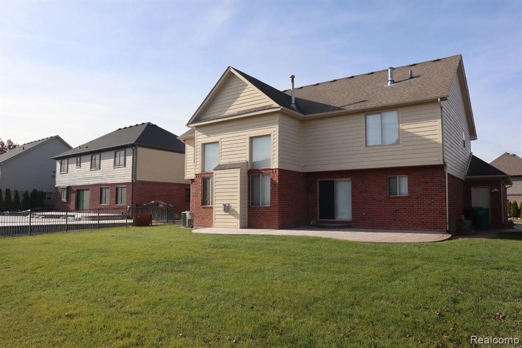 Rear view of house with brick siding and a patio area