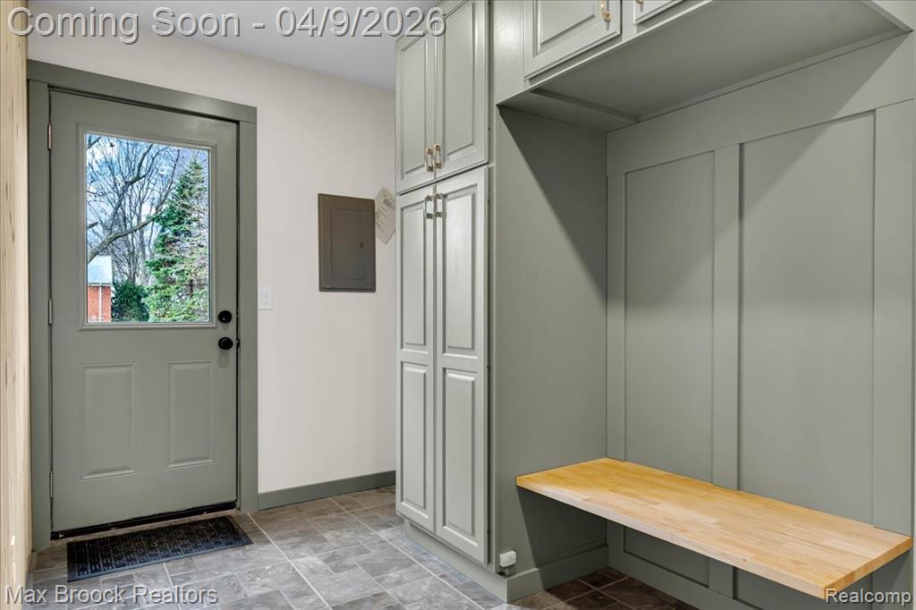Mudroom featuring stone finish flooring and electric panel