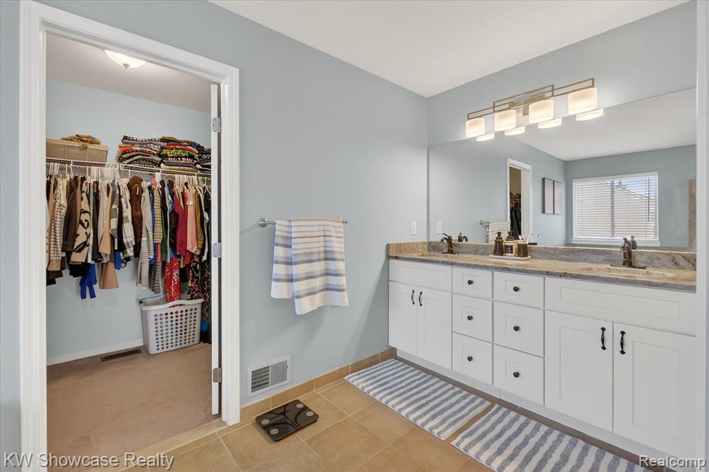 Full bath featuring a bath, a shower stall, ensuite bath, and light tile patterned floors