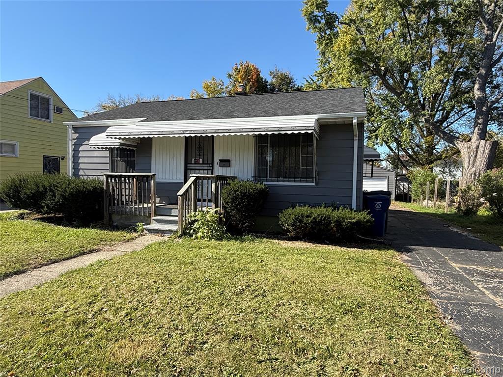 Exterior featuring horizontal siding, a covered front porch, an asphalt shingle roof, and an asphalt driveway