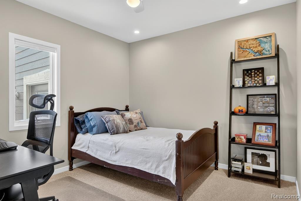 Bedroom featuring light carpet and an office area