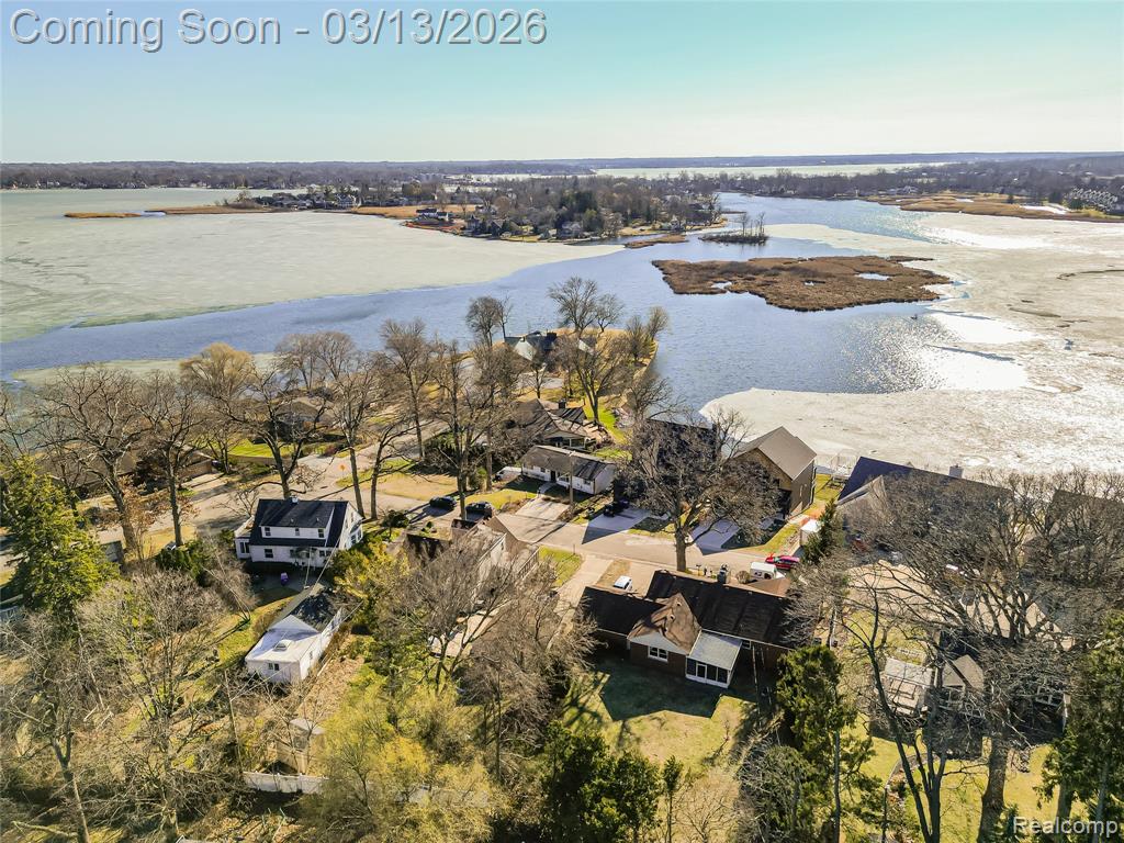 Aerial perspective of suburban area featuring a nearby body of water
