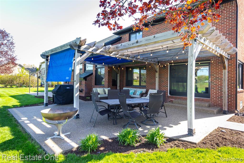 Aggregate patio with a pergola, sun shade, grilling area, and an outdoor living / dining area