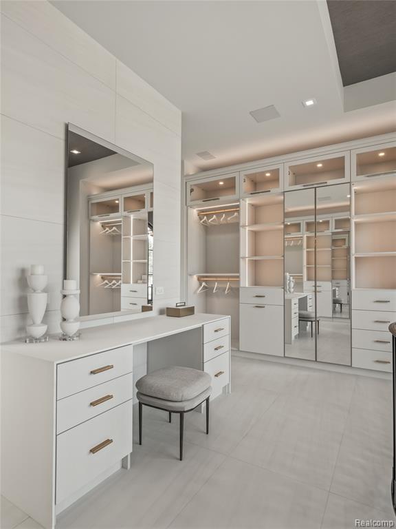 Walk in closet with light tile patterned floors