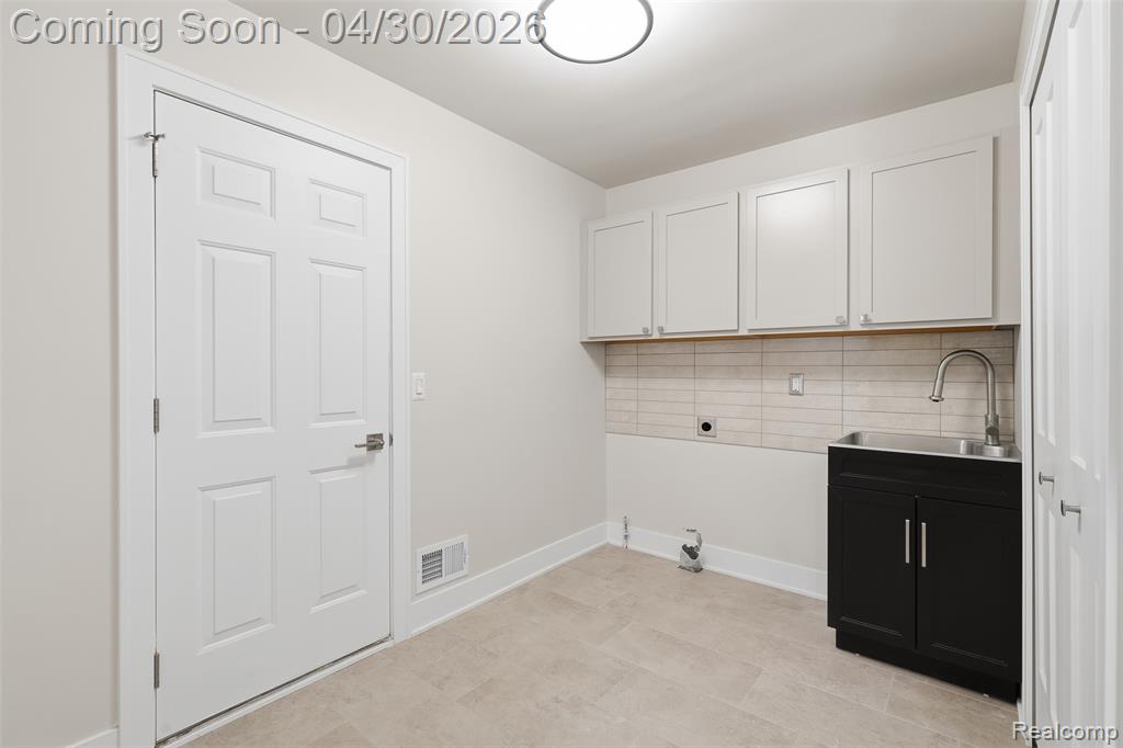 First Floor Laundry area with cabinet space and hookup for an electric dryer