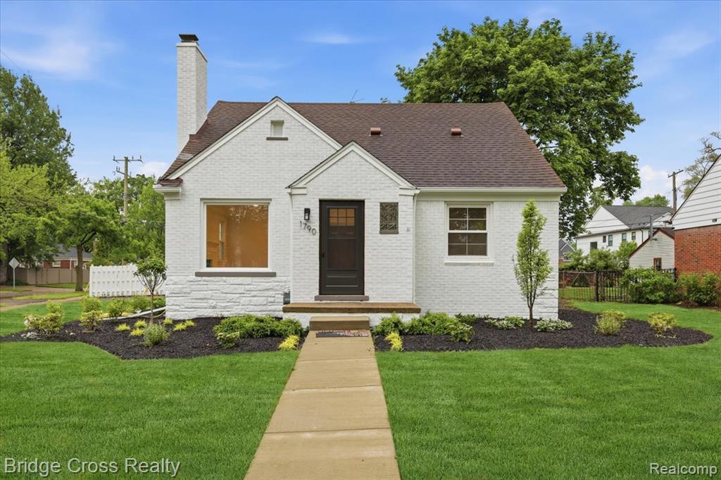 Bungalow featuring brick siding, a chimney, and roof with shingles