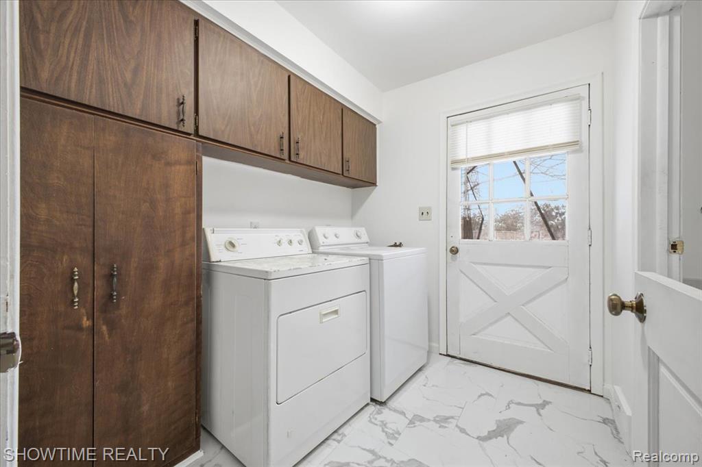 Laundry room featuring light marble finish flooring, cabinet space, and independent washer and dryer
