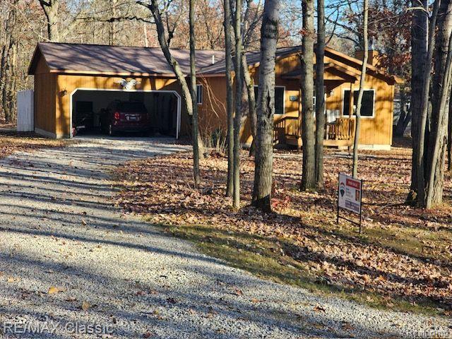 View of front facade featuring a garage and a wooden deck
