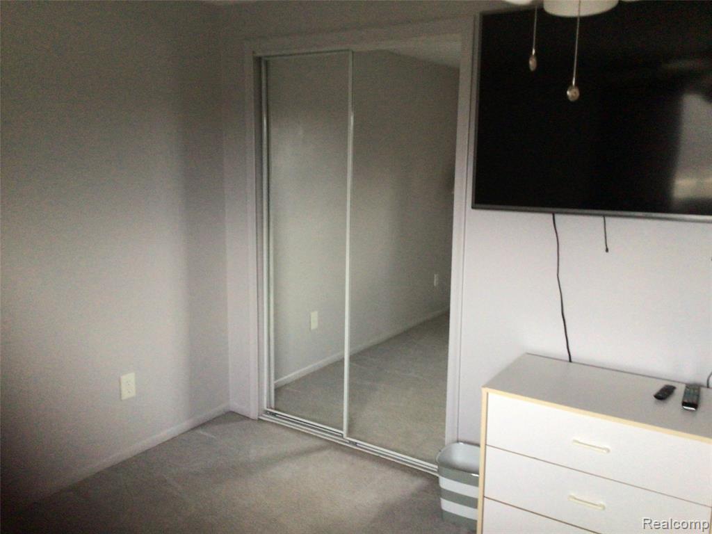 Unfurnished bedroom featuring light carpet and a closet