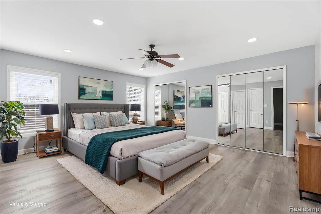 Bedroom featuring light wood-style flooring, two closets, ceiling fan, and recessed lighting