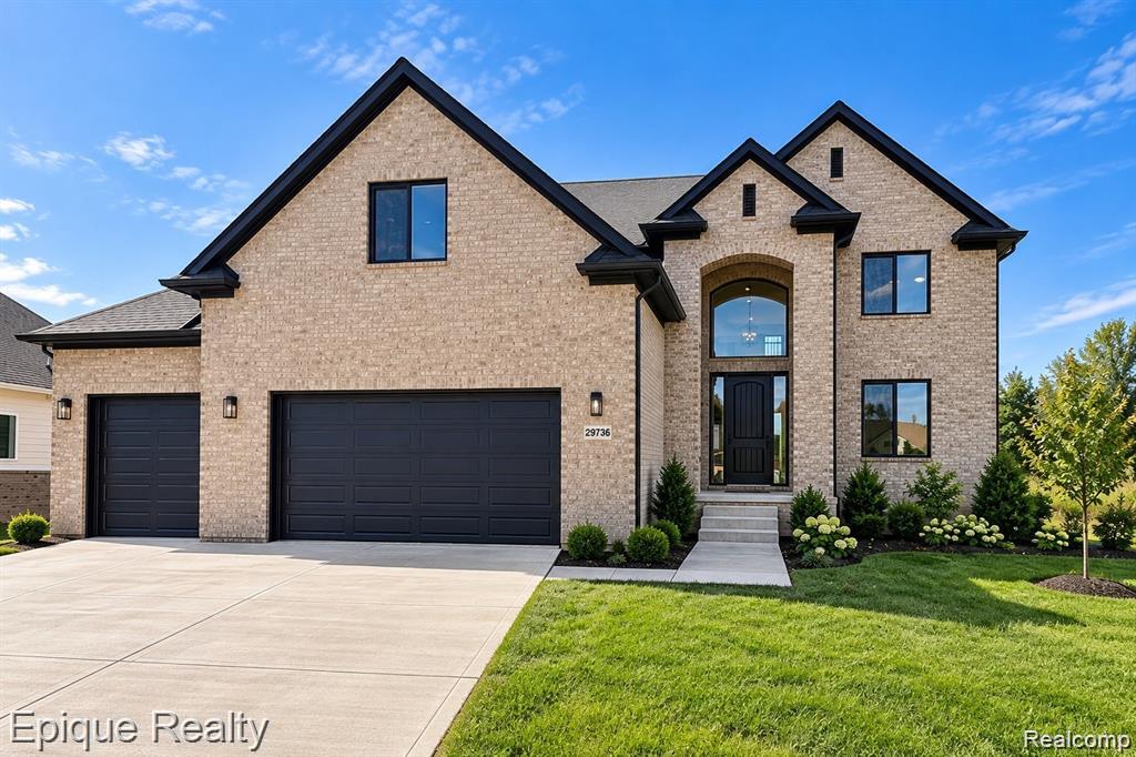 Brick exterior with black trim accents and a multi-car garage