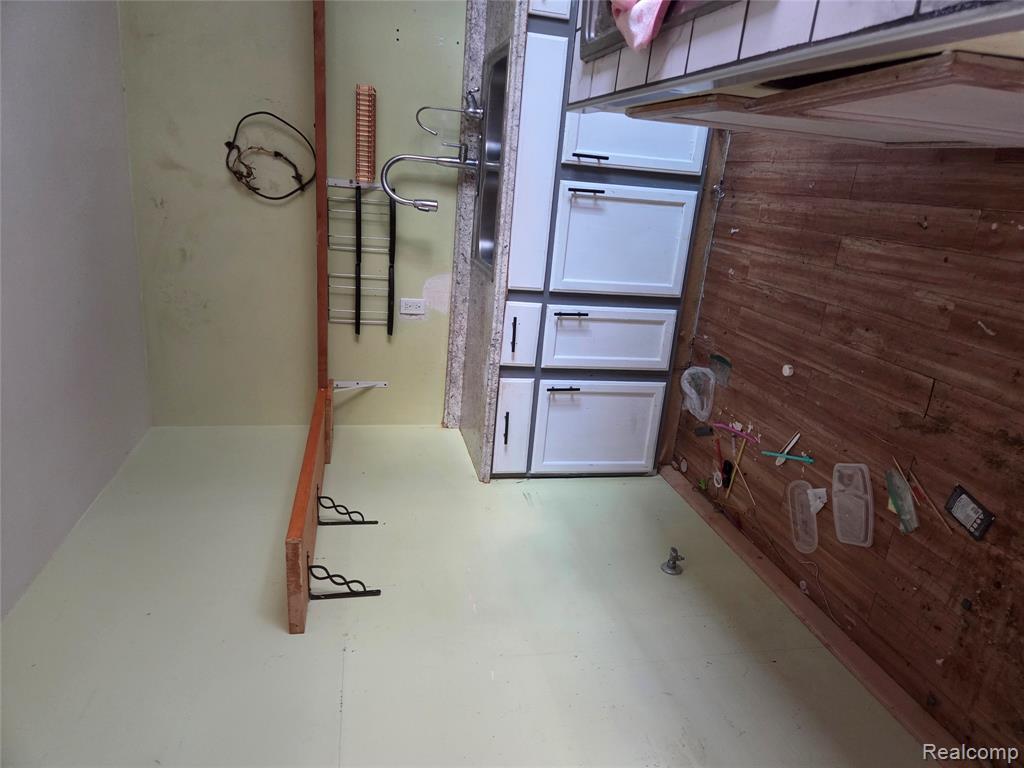 Kitchen with dark wood-type flooring, light countertops, and white cabinetry