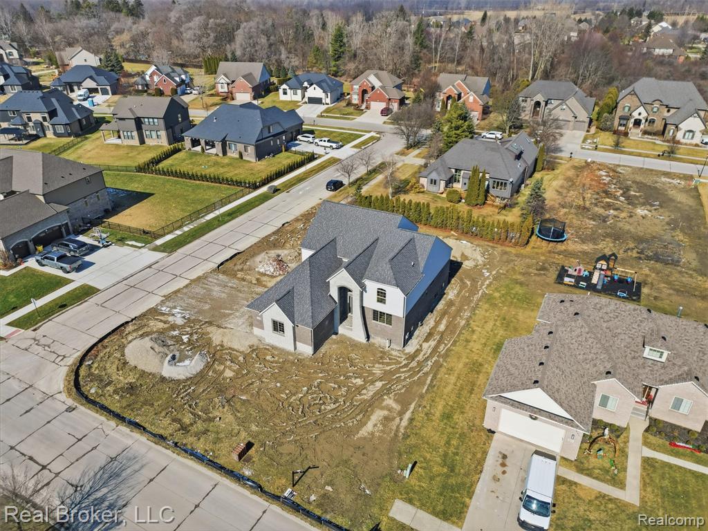 Aerial view of property and surrounding area featuring nearby suburban area