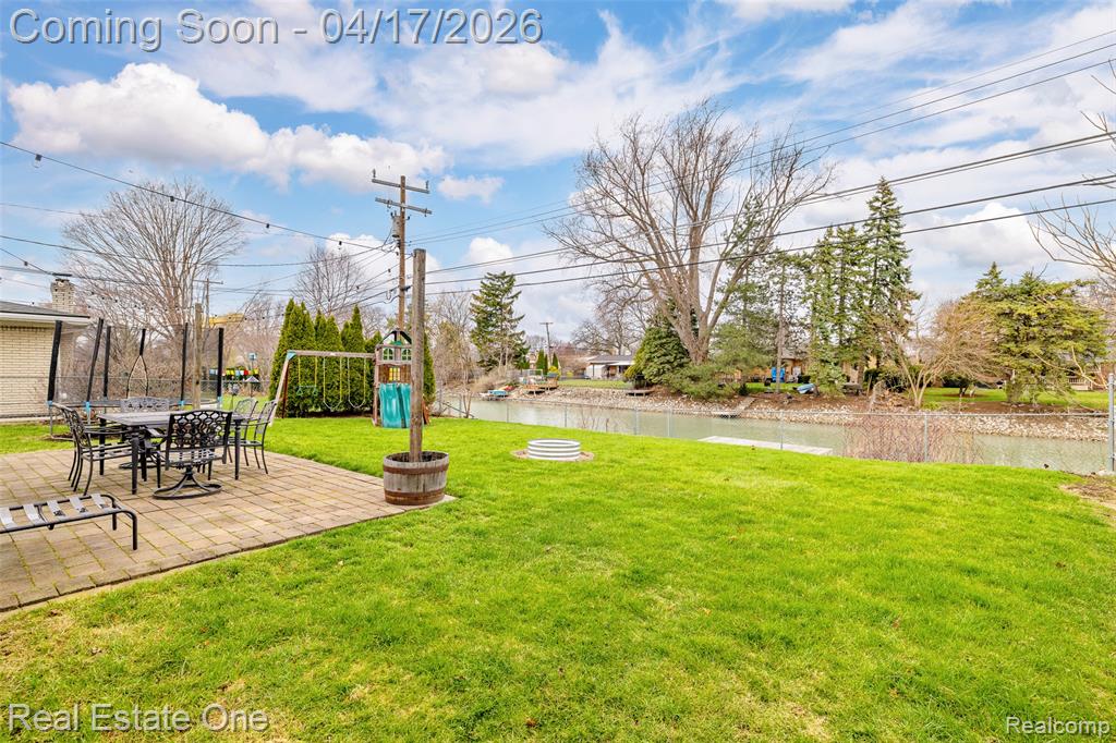 View of yard with a playground, a patio, a water view, and outdoor dining space