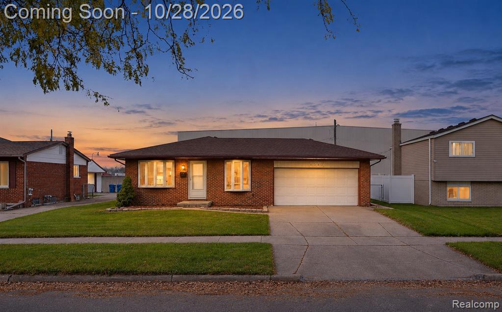 Single-story brick exterior featuring a low-slope roof, dual bay windows, and an attached two-car garage