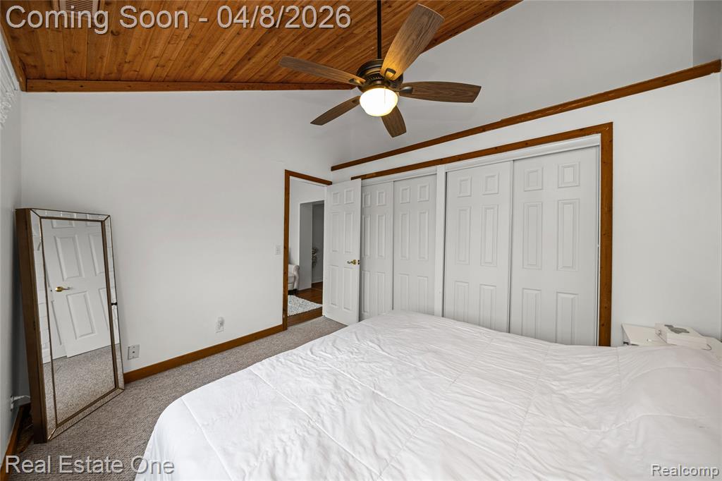 Bedroom with light carpet, a vaulted wood ceiling, ceiling fan, and a closet