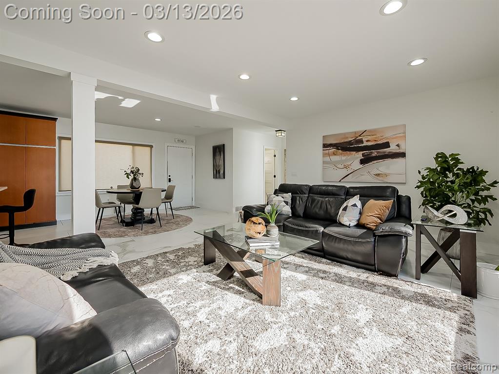 Living room featuring light marble finish floors and recessed lighting