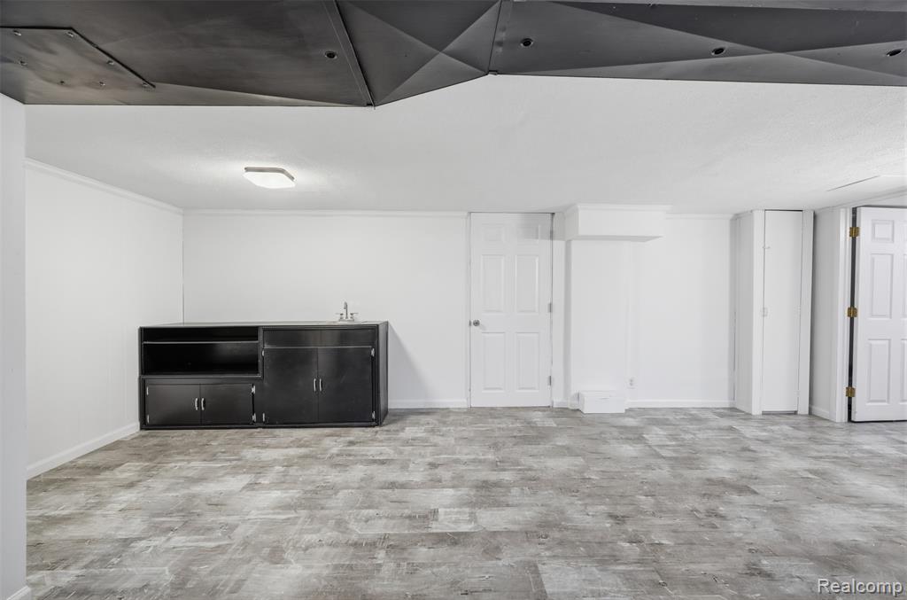 Finished below grade area with light wood-style floors and baseboards
