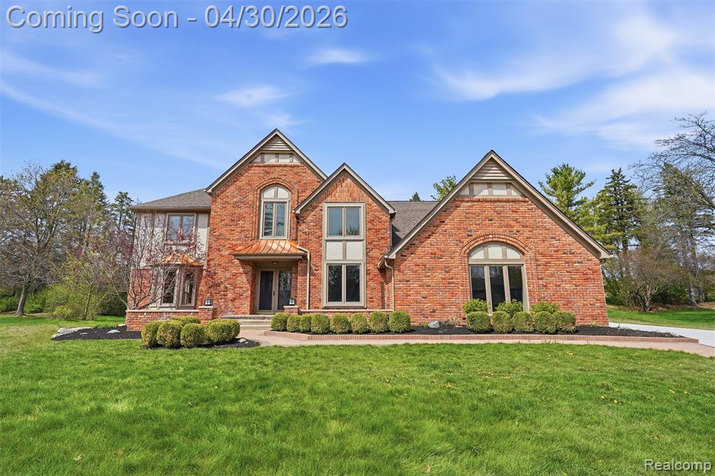 View of front of property with a front lawn and brick siding