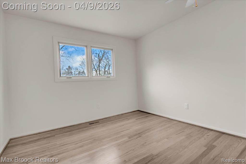 Spare room featuring light wood finished floors and baseboards