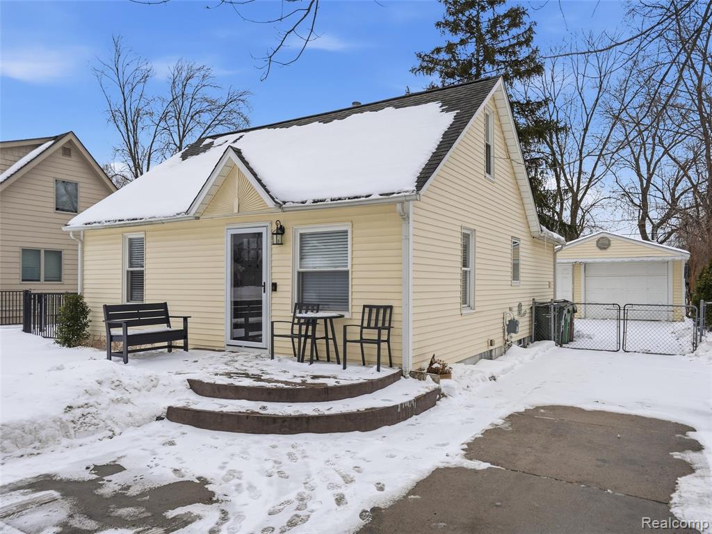 View of front of house with an outdoor structure and a detached garage