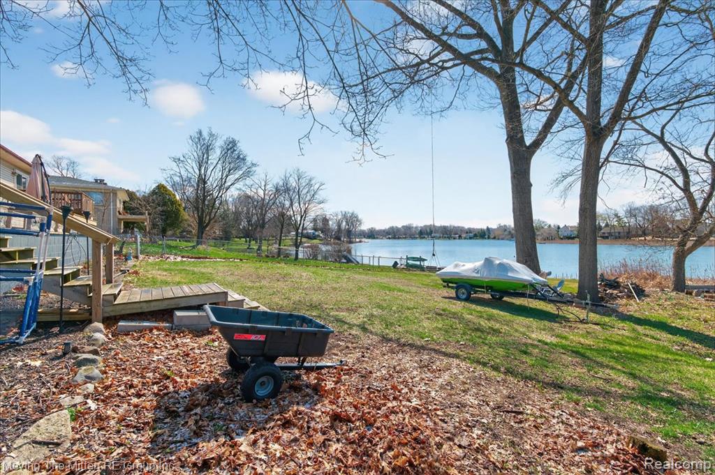 View of yard with a deck with water view
