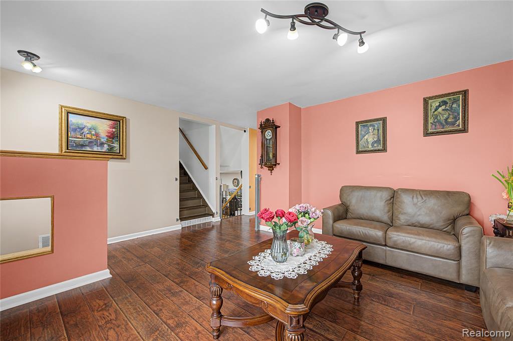 Living area with stairway and dark wood-type flooring