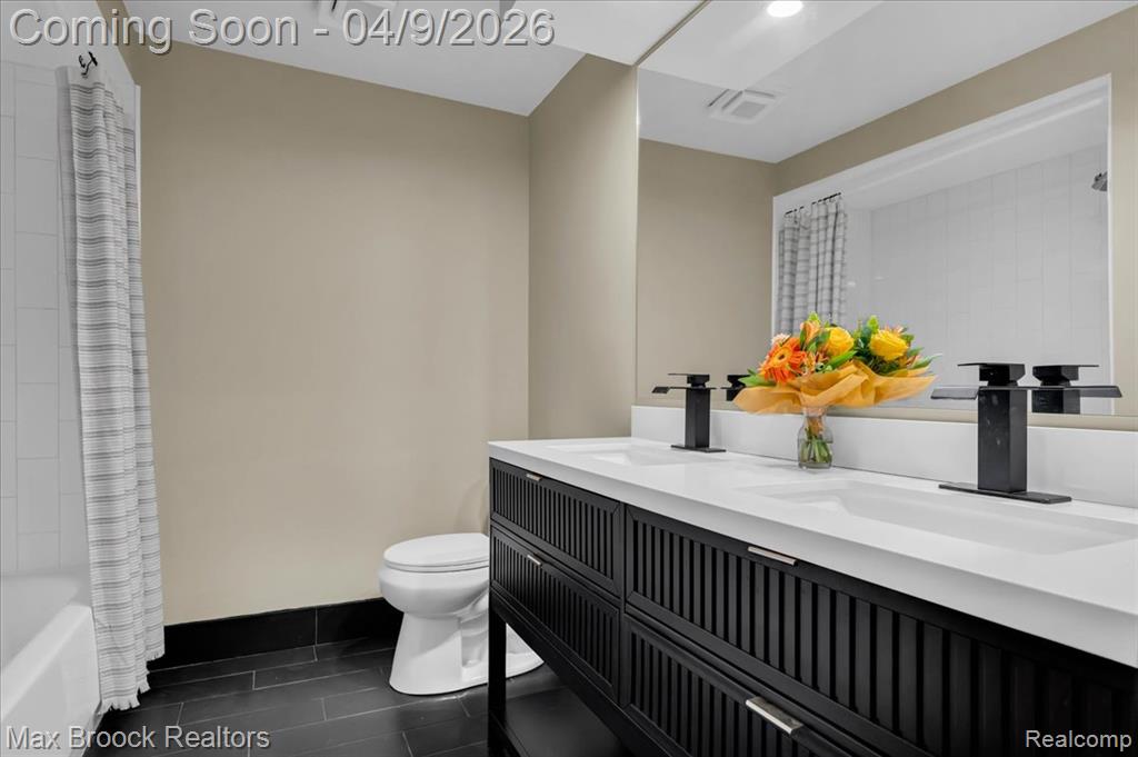 Bathroom featuring double vanity and shower / tub combo